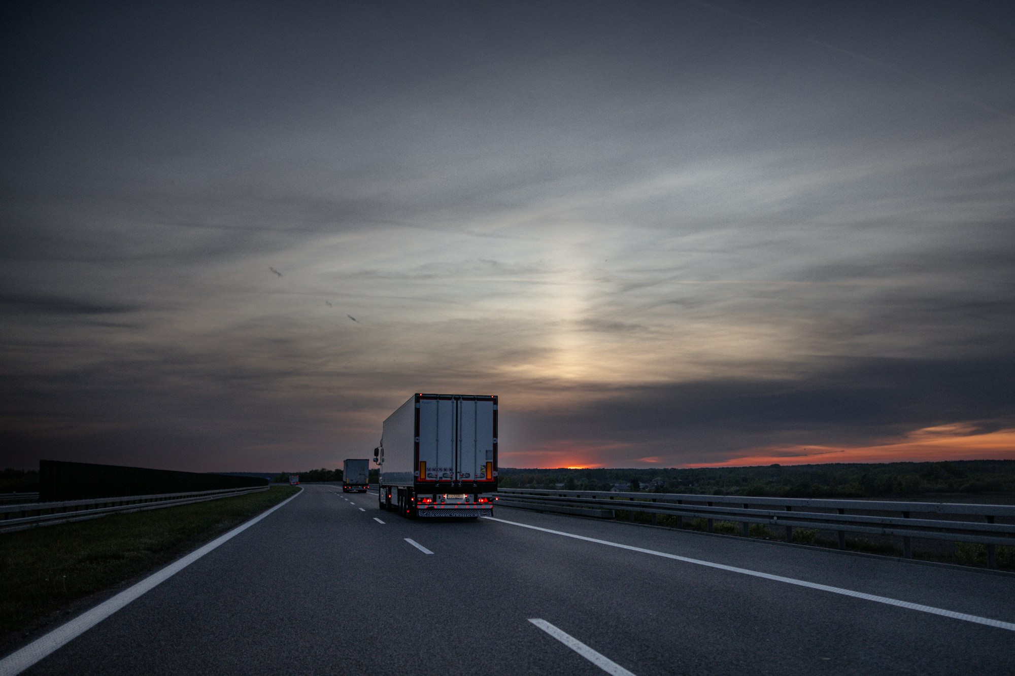 Trucks on highway at sunset